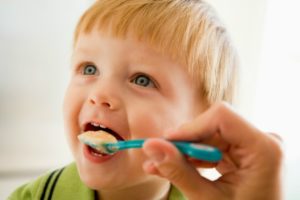 mother-feeding-young-boy-baby-food